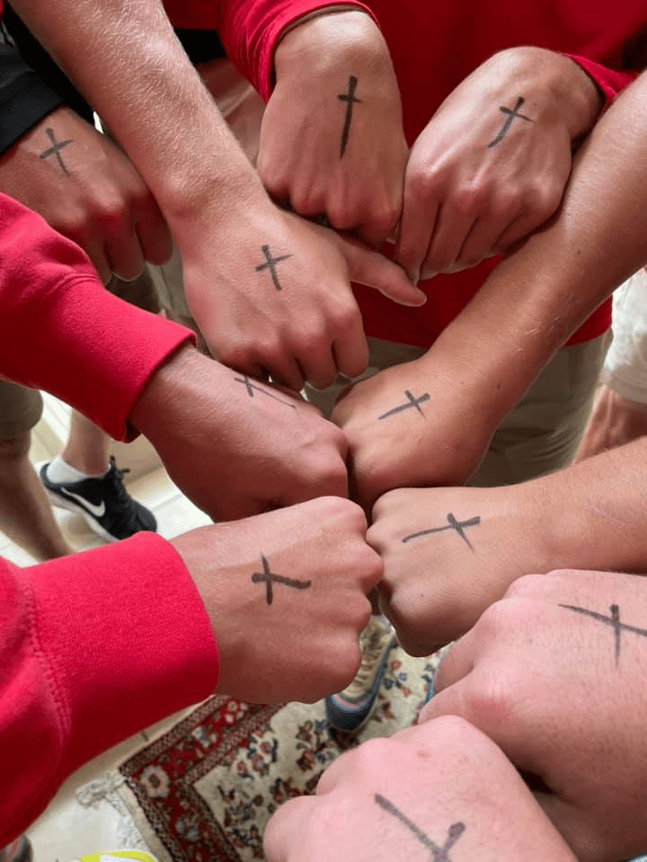Hands fist bumping with cross marks on hands